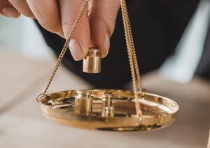 cropped image of accountant putting precision weights on scales in office